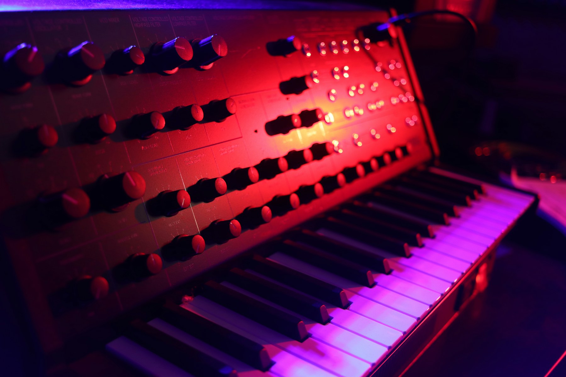 Synthesizer im farbig beleuchteten Studio